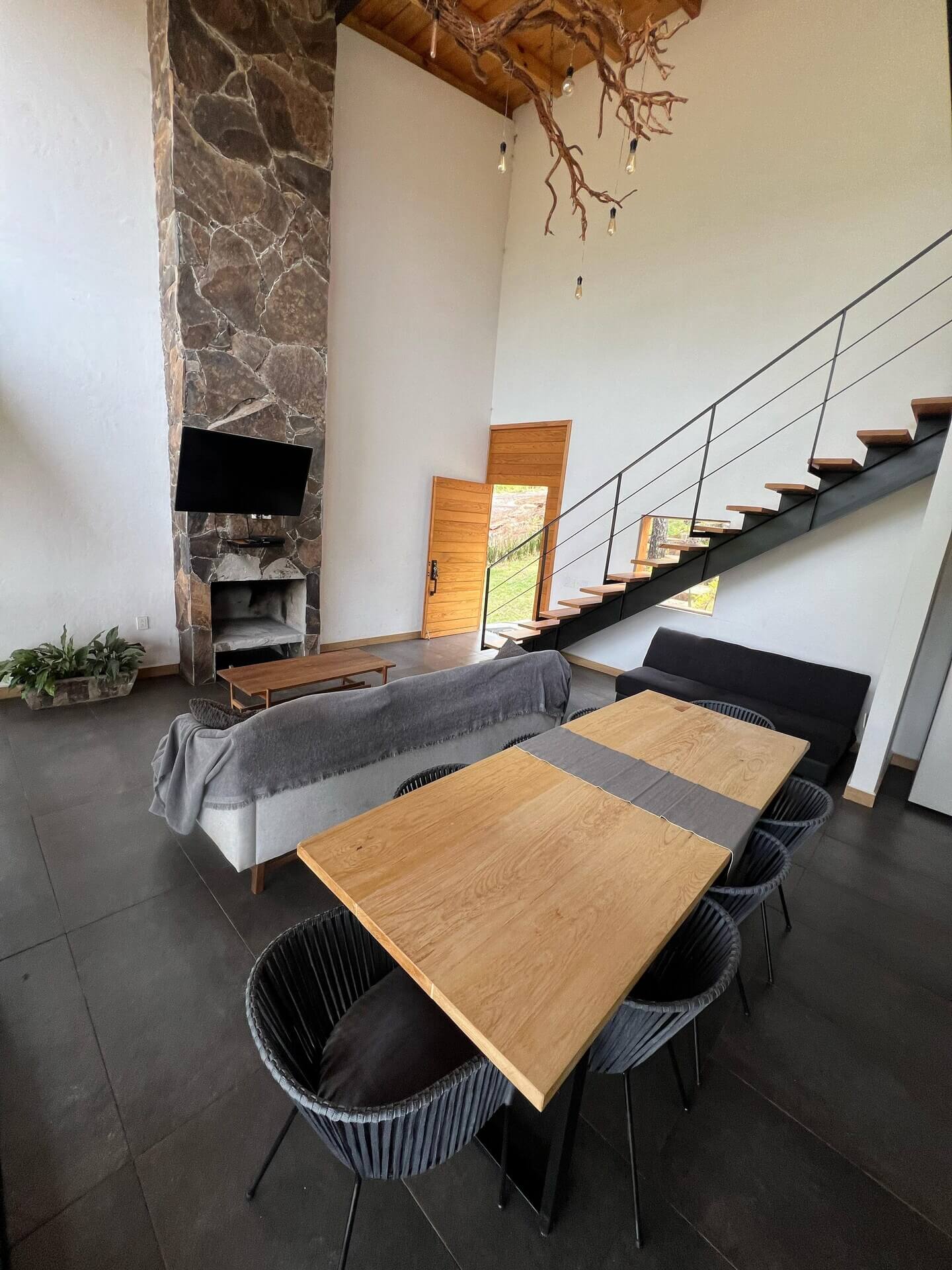 Sala de la cabaña en Mazamitla con techos altos, ventanales y chimenea